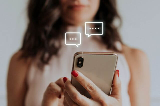 吹き出しが浮かぶ携帯を持つ女性